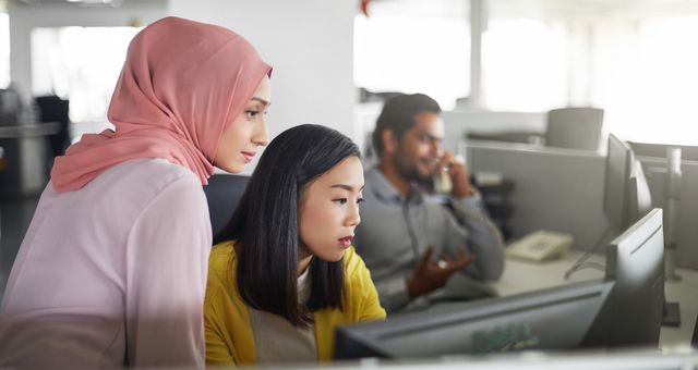 Deux femmes au travail, dont l'une porte un voile.